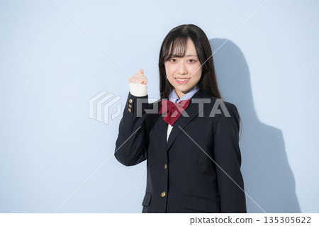 A high school girl's upper body fist pump looking at the camera against a light blue background A high school girl's upper body fist pump looking at the camera against a light blue background 135305622