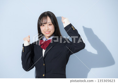 A high school girl's upper body fist pump looking at the camera against a light blue background A high school girl's upper body fist pump looking at the camera against a light blue background 135305623