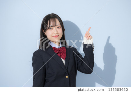 一名高中女生的上半身正對著鏡頭，背景則是淺藍色。 135305630