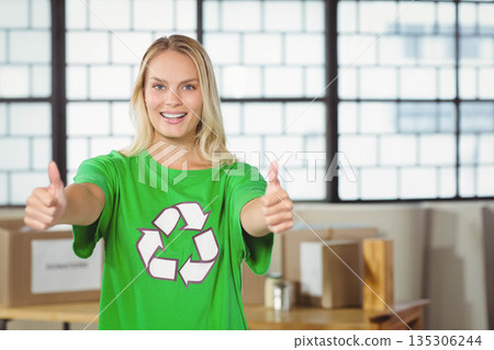 Woman wearing green recycling t-shirt sorting cardboard boxes and crates on table in community room 135306244