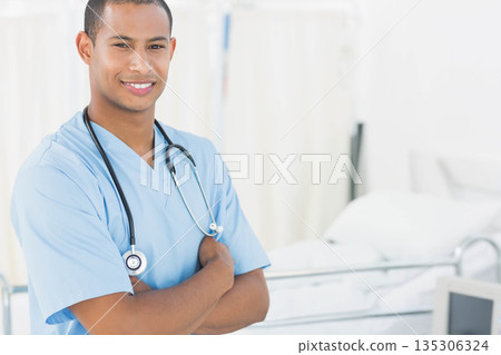 African American male doctor standing with stethoscope in ward beside patient bed rails, copy space 135306324