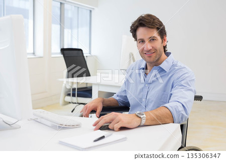 Mid adult man working at office desk by window wearing business attire using wheelchair, copy space Mid adult man working at office desk by window wearing business attire using wheelchair, copy space 135306347