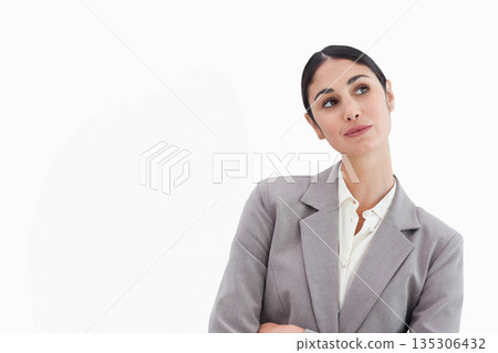 Woman wearing grey blazer and white blouse standing with arms crossed gazing sideways in studio Woman wearing grey blazer and white blouse standing with arms crossed gazing sideways in studio 135306432