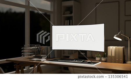 White screen computer and document folders aside lamp on wooden working table in dim lit living room 135306541