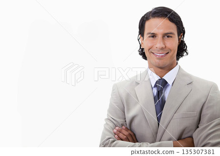Man standing with arms crossed in studio wearing gray suit striped tie, copy space Man standing with arms crossed in studio wearing gray suit striped tie, copy space 135307381