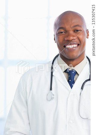 African American male doctor standing in clinic office wearing lab coat and stethoscope, copy space 135307415