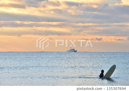 Surfing and guard boats in the morning glow on New Year's Day 135307694