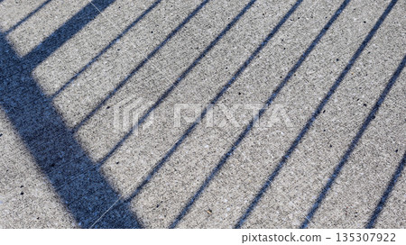 The shadow of a fence on the asphalt The shadow of a fence on the asphalt 135307922