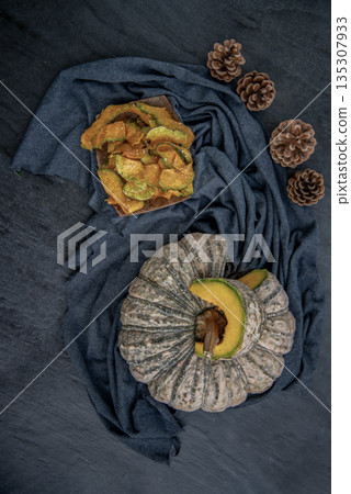 Flat Lay composition with delicious of Homemade crispy pumpkin chips on Black stone texture. Flat Lay composition with delicious of Homemade crispy pumpkin chips on Black stone texture. 135307933