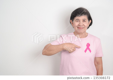Elderly woman with pink Ribbon for Pink October Breast Cancer Awareness month, May Women Health, February World cancer day, support people life and illness. National cancer survivors month Elderly woman with pink Ribbon for Pink October Breast Cancer Awareness month, May Women Health, February World cancer day, support people life and illness. National cancer survivors month 135308172