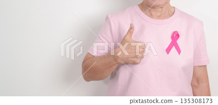 Elderly woman with pink Ribbon for Pink October Breast Cancer Awareness month, May Women Health, February World cancer day, support people life and illness. National cancer survivors month 135308173