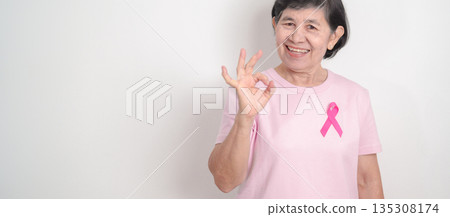 Elderly woman with pink Ribbon for Pink October Breast Cancer Awareness month, May Women Health, February World cancer day, support people life and illness. National cancer survivors month 135308174