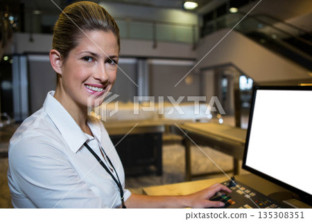 Female staff member operating control panel beside monitor at banquet buffet station, copy space 135308351