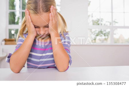 Girl leaning head on hands, sitting at white table at home by window with woven basket Girl leaning head on hands, sitting at white table at home by window with woven basket 135308477
