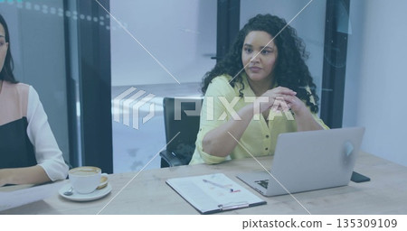 Woman in light yellow blouse listening in meeting room, with laptop clipboard smartphone and coffee Woman in light yellow blouse listening in meeting room, with laptop clipboard smartphone and coffee 135309109