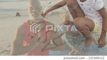 Family meditating and praying on sandy shoreline, with child tracing heart shape with feather Family meditating and praying on sandy shoreline, with child tracing heart shape with feather 135309122