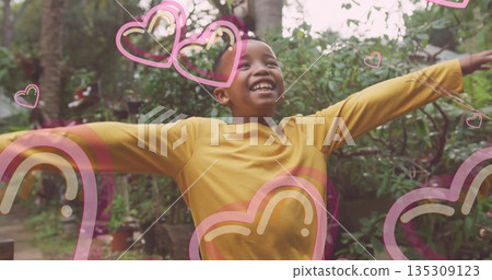 Smiling boy raising arms and lifting chin in backyard garden, with heart and rainbow overlays Smiling boy raising arms and lifting chin in backyard garden, with heart and rainbow overlays 135309123
