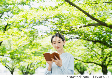 Young woman reading outdoors Lifestyle image Young woman reading outdoors Lifestyle image 135309225
