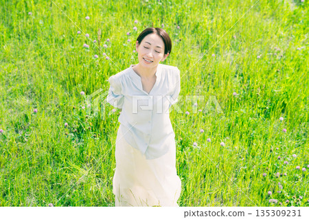 Young woman stretching in the grassland Lifestyle image Young woman stretching in the grassland Lifestyle image 135309231