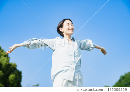 Young woman stretching outdoors Lifestyle image Young woman stretching outdoors Lifestyle image 135309239