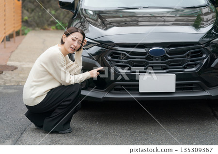 女性檢查汽車划痕 女性檢查汽車划痕 135309367