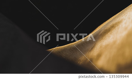 Unique texture of fabric illuminated by soft light in a dark setting showcasing elegant curves and shadows Unique texture of fabric illuminated by soft light in a dark setting showcasing elegant curves and shadows 135309944