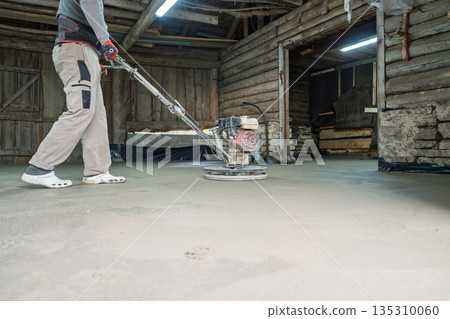 Concrete Polishing Worker Smoothing Surface with Grinding Machine in Rustic Building 135310060