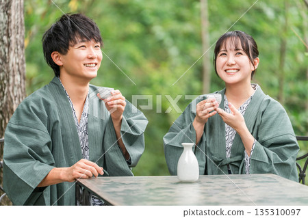 Couple drinking sake while enjoying forest bathing on a trip Couple drinking sake while enjoying forest bathing on a trip 135310097