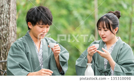 Couple drinking sake while enjoying forest bathing on a trip Couple drinking sake while enjoying forest bathing on a trip 135310098