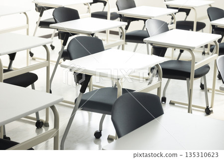 A school classroom with rows of desks and chairs 135310623