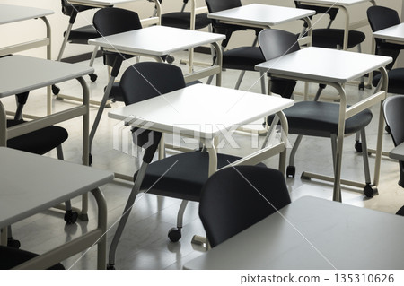 A school classroom with rows of desks and chairs 135310626