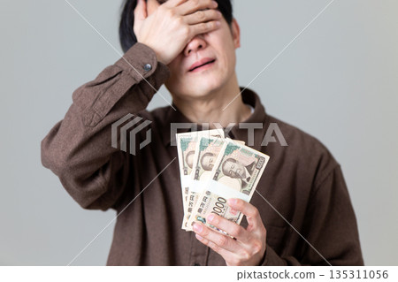 一位身著休閒裝的中年男性商人，正為錢煩惱。 135311056