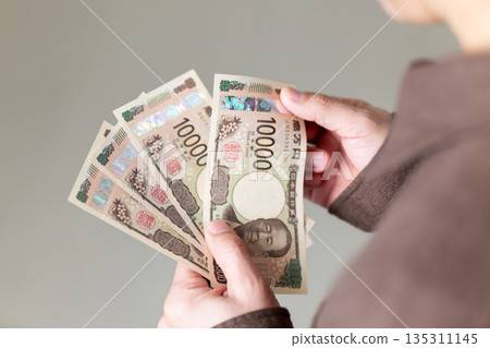 身著休閒裝的中年男性商人手持鈔票 135311145