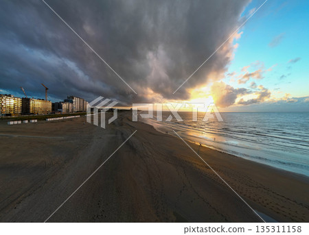 Savoring the Peace and Beauty of a Serene Coastal Sunset Over a Tranquil Beachscape 135311158