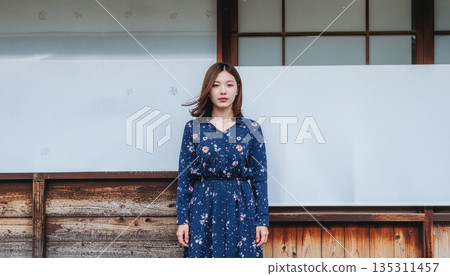 A young woman standing in front of a Japanese house 135311457