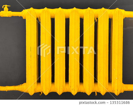 Bright yellow radiator against dark background for industrial design. Bright yellow radiator against dark background for industrial design. 135311686