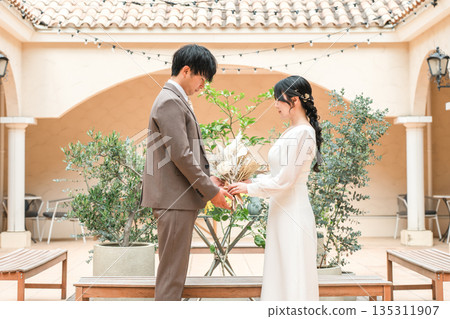 新娘和新郎拿著花束互相凝視(婚禮、新娘、情侶) 新娘和新郎拿著花束互相凝視(婚禮、新娘、情侶) 135311907