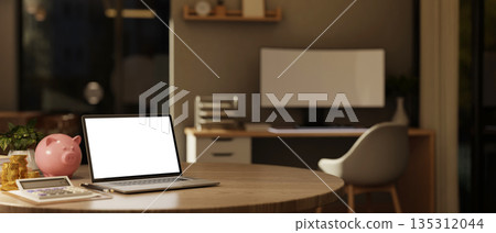 White screen laptop with calculator gold coin and piggy bank on wood table in bedroom or living room 135312044