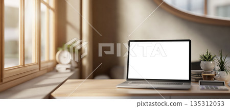 Blank screen laptop with calculator and coffee aside plant on wooden table in bedroom or living room 135312053