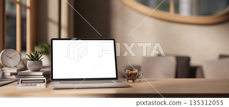 White screen laptop with calculator and coffee cup aside plants on wooden table in a bedroom or living room. 135312055