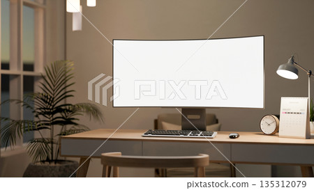 Bank curved screen computer with clock, calendar under lamp light on wooden table in a living room. 135312079