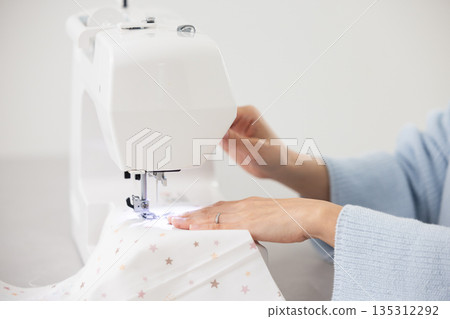 Close-up of a woman's hands sewing 135312292