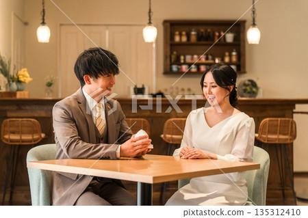A man proposing at a restaurant and a woman receiving a ring 135312410