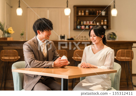 一名男子在餐廳向女子求婚,女子收到一枚戒指。 一名男子在餐廳向女子求婚,女子收到一枚戒指。 135312411