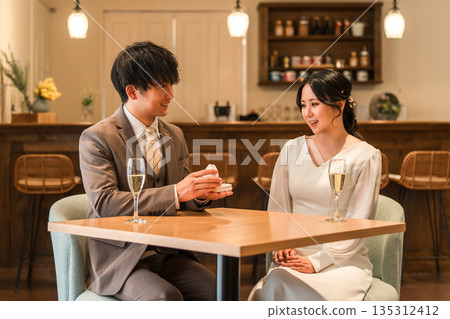 一名男子在餐廳向女子求婚,女子收到一枚戒指。 一名男子在餐廳向女子求婚,女子收到一枚戒指。 135312412