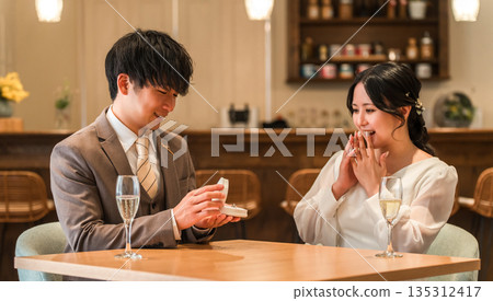 一名男子在餐廳向一名女子提出出人意料的求婚。 一名男子在餐廳向一名女子提出出人意料的求婚。 135312417