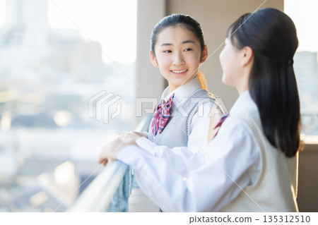 放學後,一名國中女生站在學校陽台上向外眺望。 放學後,一名國中女生站在學校陽台上向外眺望。 135312510