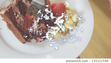 Holding white plate with chocolate cake slice over cafe table, showing raspberries, popcorn, fork Holding white plate with chocolate cake slice over cafe table, showing raspberries, popcorn, fork 135312548