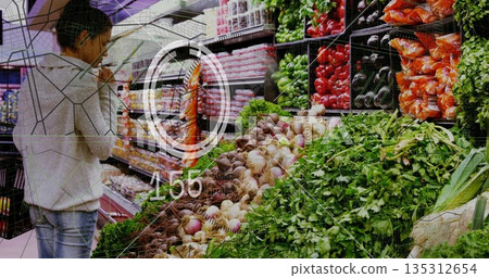 Browsing woman selecting carrots and peppers in produce aisle, with shopping basket, copy space 135312654