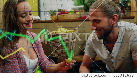 Smiling couple wearing plaid shirt holding green pear in kitchen with wicker baskets, stock overlay 135312658